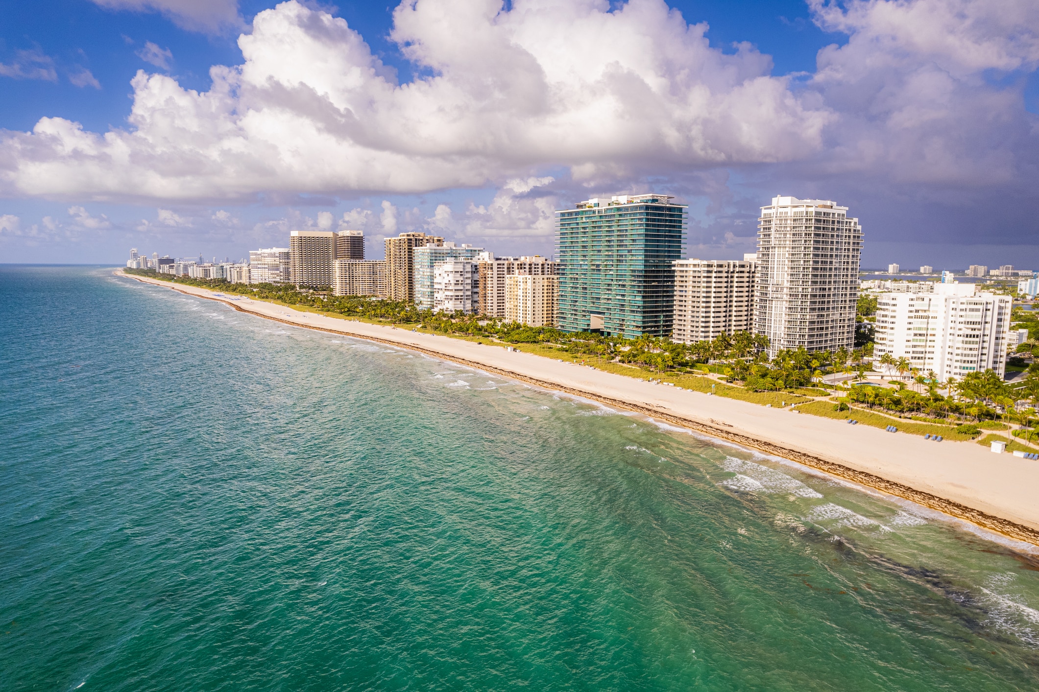 An aerial view of Naples Beach with buildings along the sandy shoreline. Florida