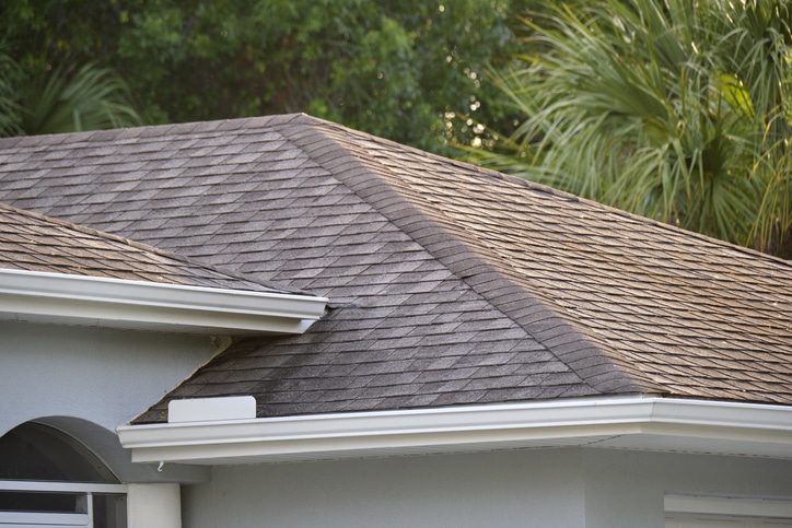 Closeup of house roof top covered with asphalt or bitumen shingles. Waterproofing of new building.