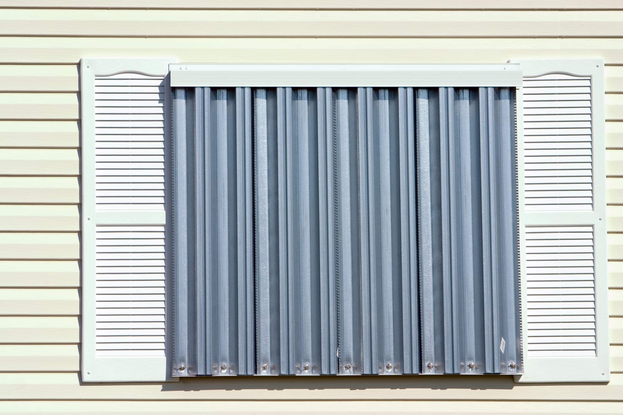 Hurricane protection corrugated metal panels installed on tropical home